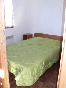 a bedroom with a green bed in a room at ZEcamping 3 étoiles avec piscine et pataugeoire in Saint-Projet