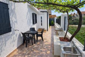 a patio with a table and chairs and a sink at Solmar Adriatica Apartman in Banjole