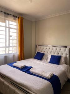 a bedroom with a large bed with blue pillows at Blissful Homes in Thika