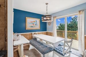 a dining room with a white table and chairs and a window at 3979 - Wright by the Coast in Duck