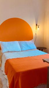 a bed with an orange headboard in a room at Bossa Nova Home in Barra dos Coqueiros