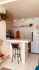 a kitchen with a black chair and a white refrigerator at Bossa Nova Home in Barra dos Coqueiros