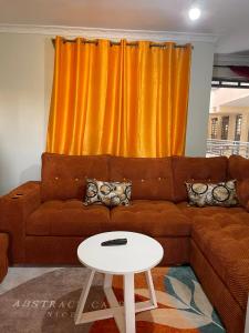 a living room with a brown couch and a white table at Blissful Homes in Thika
