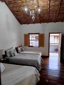 a bedroom with two beds and a chandelier at Pedacinho do céu in Tiradentes +34 photos