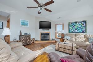 a living room with couches and a flat screen tv at 3941 - Fleur de Duck in Duck