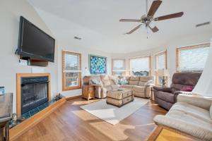 a living room with a flat screen tv and a fireplace at 3941 - Fleur de Duck in Duck