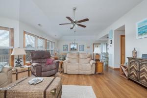 a living room with two chairs and a ceiling fan at 3941 - Fleur de Duck in Duck