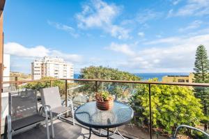 a balcony with a table and chairs and the ocean at Tamariz Flat in Santa Cruz