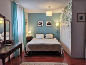 a bedroom with a bed and a table and a mirror at La Maison d'Eana in Maintenon