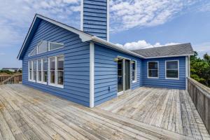 a blue house on a wooden deck at 3213 - Seaside Salvation in Duck