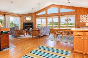 a kitchen and living room with a table and chairs at 3213 - Seaside Salvation in Duck