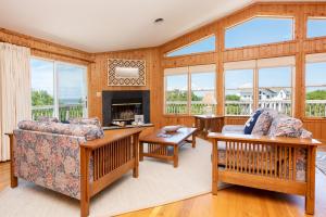 a living room with a couch and a fireplace at 3213 - Seaside Salvation in Duck +35 photos