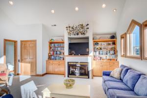 a living room with a blue couch and a fireplace at 4052 - Mirth N Mist II in Duck +45 photos