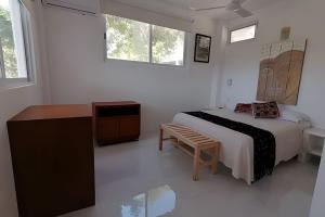 a bedroom with a bed and a table and windows at Valentina Salchi suites virgin beaches internet in Cuatunalco