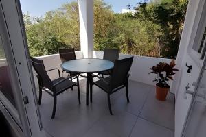 a table and four chairs on a balcony at Valentina Salchi suites virgin beaches internet in Cuatunalco