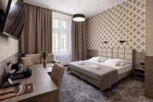 a bedroom with a bed and a desk and a couch at Hotel Maksymilian in Krakow