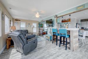 a living room with a bar and a kitchen at 7022 - East Point El Dorado in Rodanthe