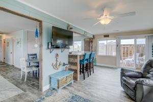 a living room with a couch and a tv and a table at 7022 - East Point El Dorado in Rodanthe