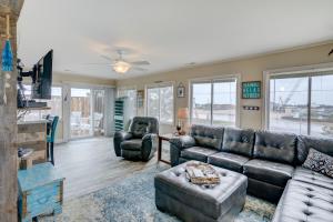 a living room with a leather couch and chairs at 7022 - East Point El Dorado in Rodanthe
