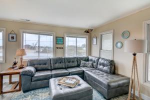a living room with a leather couch and a table at 7022 - East Point El Dorado in Rodanthe +36 photos