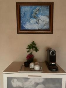 a table with a coffee maker and a picture on the wall at Campe-Good in Kampenhout +10 photos