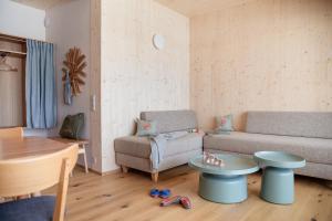 a living room with a couch and a table at biYou Ecoquartier in den Bergen in Schladming +58 photos