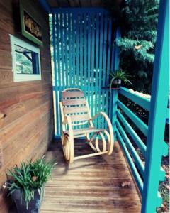 a rocking chair sitting on the porch of a cabin at Chalet Zen dans les landes in Castets +2 photos