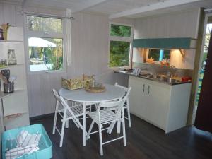 a kitchen with a table and chairs in a kitchen at Chalet Zen dans les landes in Castets