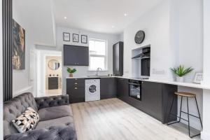 a living room with a couch and a kitchen at Romantic getaway with private hot tub in Belfast