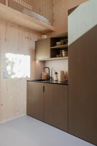 a kitchen with a brown cabinet in a room at biYou Ecoquartier in den Bergen in Schladming