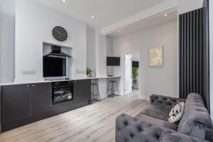 a living room with a couch and a tv at Romantic getaway with private hot tub in Belfast