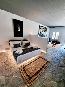 a bedroom with a bed with a cross on the wall at Mykonos Dot Art Homes in Ano Mera +48 photos