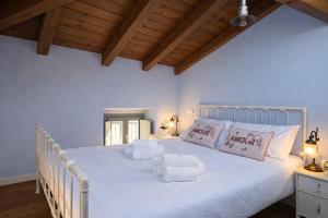ein Schlafzimmer mit einem weißen Bett, weißen Laken und Kissen. in der Unterkunft Greif Boutique Juna in Aurisina