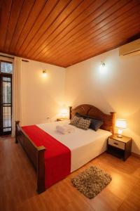 a bedroom with a large bed with a red blanket at Airport Serenity Villa - Near Colombo Airport in Katunayaka