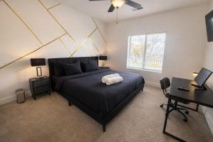 a bedroom with a black bed and a desk at Designer UAB Condo King Bed Balcony View 2 in Birmingham