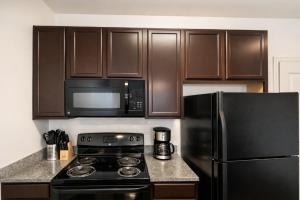 a kitchen with a black stove and a microwave at Designer UAB Condo King Bed Balcony View 2 in Birmingham
