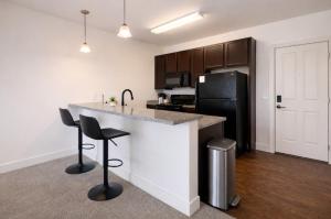 a kitchen with a counter and two bar stools at Designer UAB Condo King Bed Balcony View 2 in Birmingham +10 photos