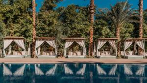 a wedding set up by a pool with palm trees at Le Bled Ferme in Marrakesh