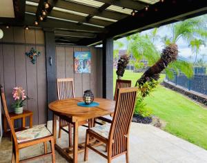 a wooden table and chairs on a patio at Unit 18 Relaxing Oceanview Studio in Pahala