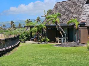a house with a yard with palm trees at Unit 18 Relaxing Oceanview Studio in Pahala