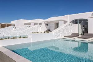 a villa with a swimming pool in front of a house at Paros Agnanti Resort & Spa in Parikia