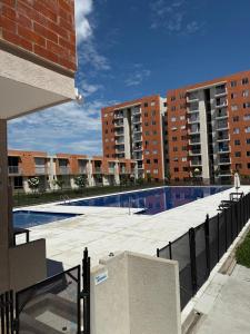 a large swimming pool with buildings in the background at Casa ibague in Ibagué