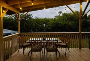 a patio with a table and chairs on a deck at Yurt BenTiki in Naalehu
