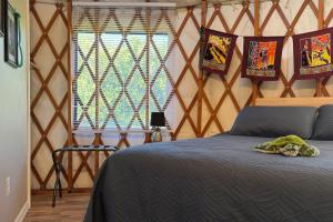 a bedroom with a bed and a chair in a room at Yurt BenTiki in Naalehu