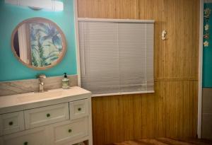 a bathroom with a sink and a mirror and a window at Yurt BenTiki in Naalehu +23 photos