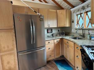 a kitchen with a stainless steel refrigerator and wooden cabinets at Yurt BenTiki in Naalehu