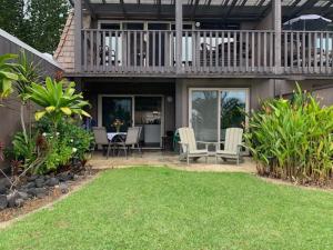 a house with a deck and a table and chairs at 41 Turtle Hut in Pahala