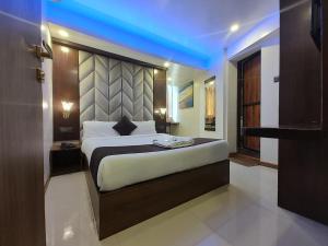 a bedroom with a large bed with a blue light at Hotel Rio in Mumbai