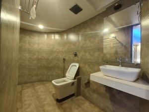a bathroom with a toilet and a sink at Hotel Rio in Mumbai