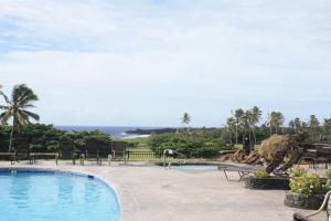 a swimming pool with a view of the ocean at 43 Studio Queen Bed in Pahala